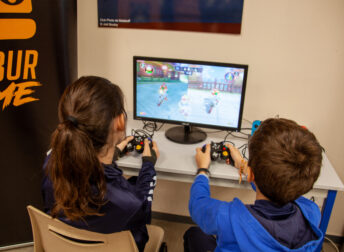 Stage sport et jeu vidéo : une fille et un garçon qui joue à Mario Kart