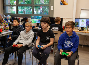 Stage sport et jeu vidéo : enfants concentrés pendant tournois de jeu vidéo